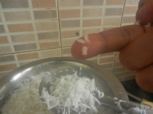 Rice checking उंगली पर चावल का पका होना देखते हुए